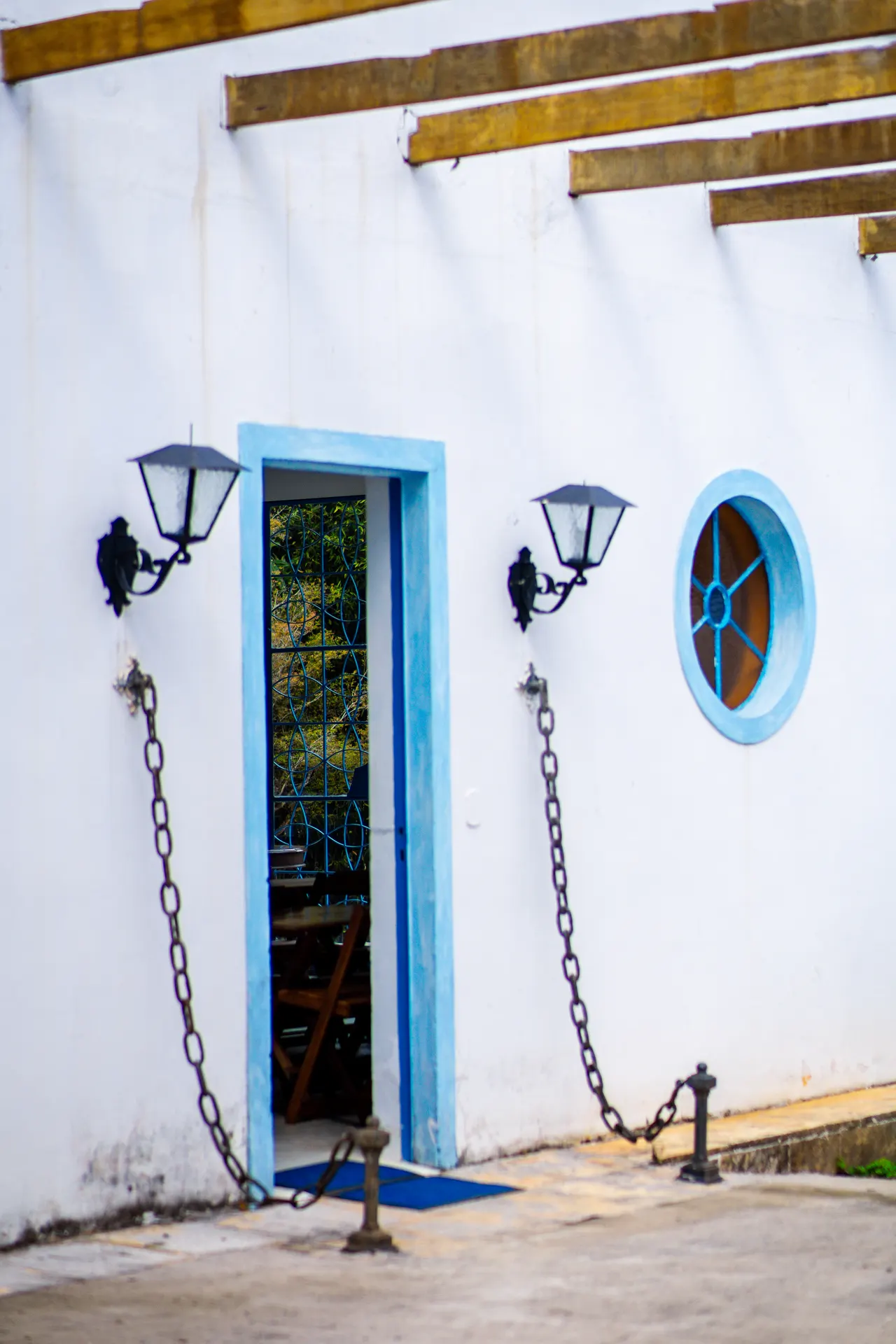 Porta com luminárias e janela redonda azul