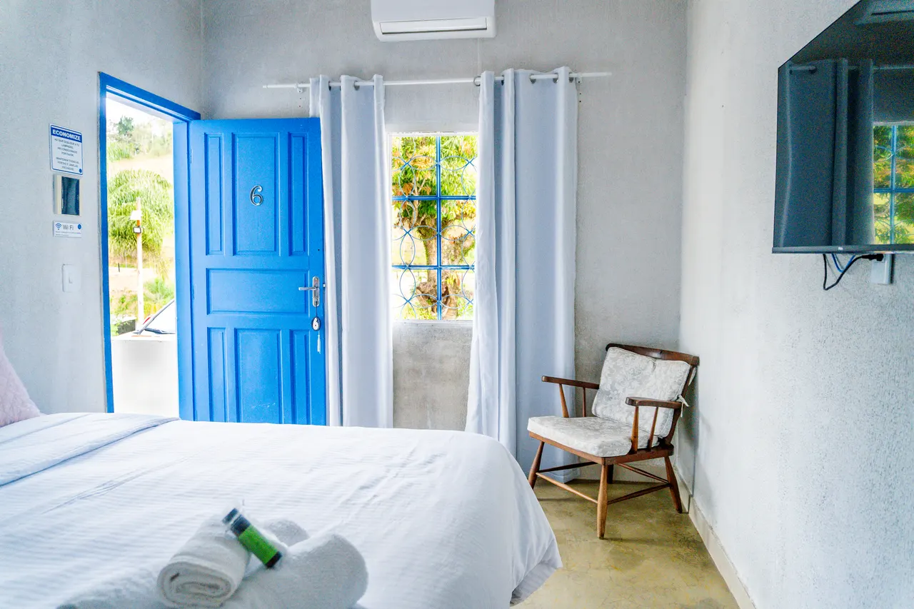 Quarto de casal com porta azul e TV