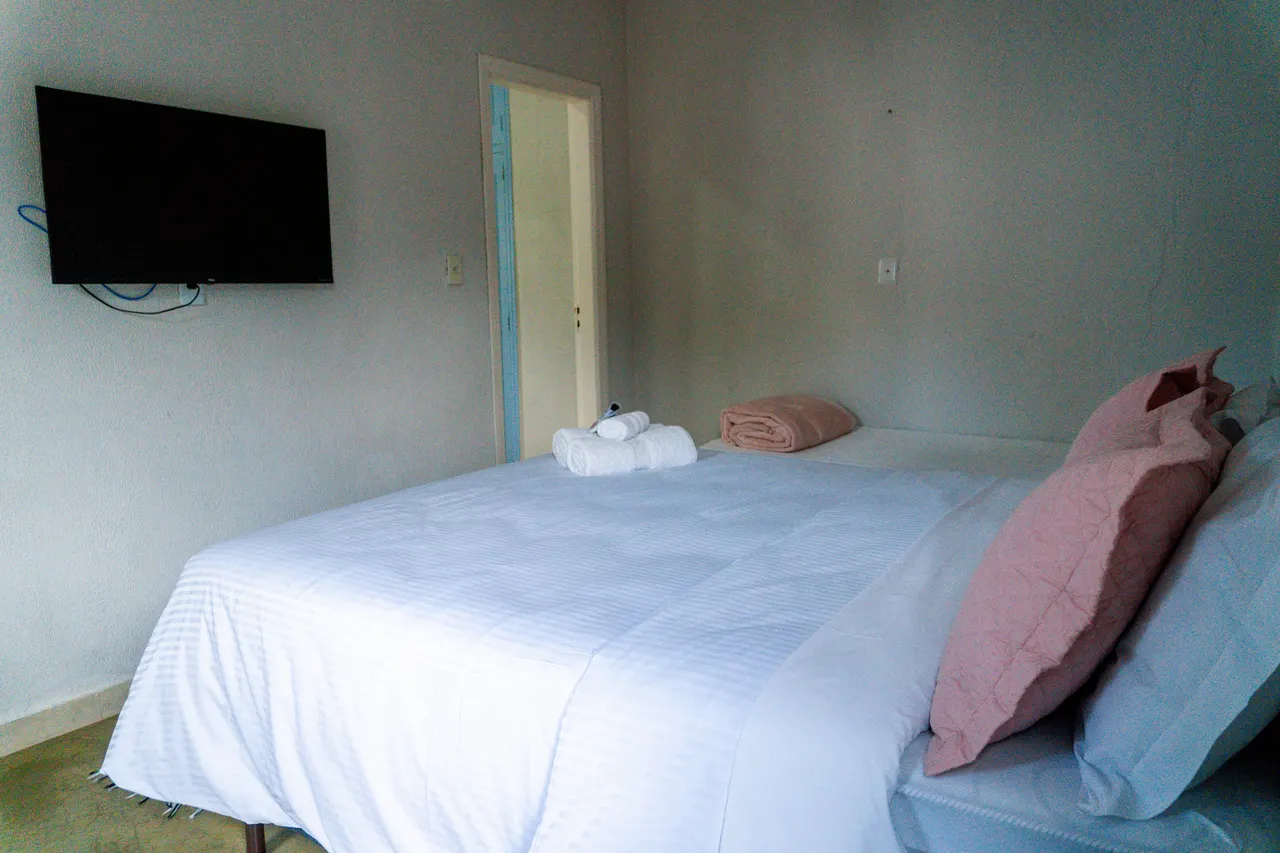 Cama de casal com enxoval branco