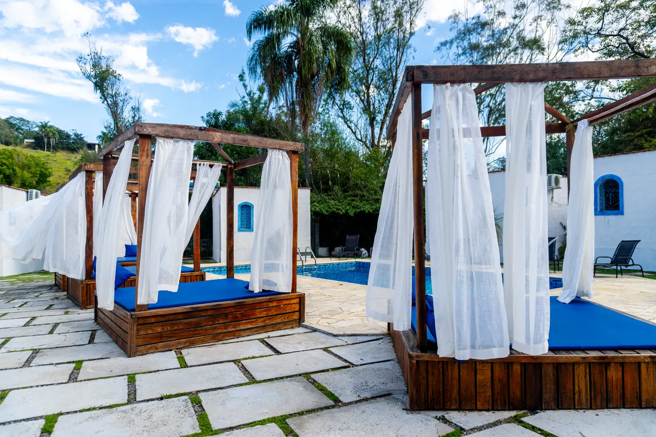 Cabanas com cortinas brancas à beira da piscina