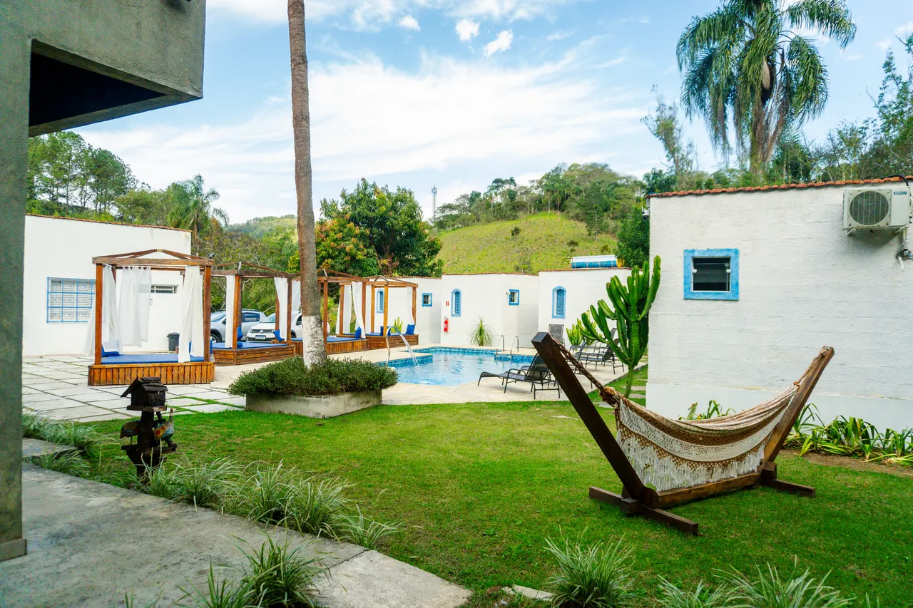Jardim com rede e a piscina ao fundo