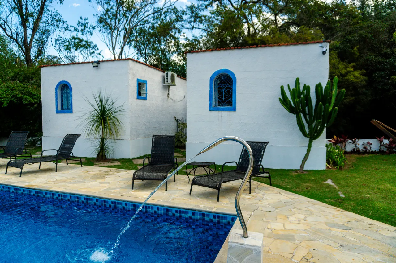 Piscina cercada pelos chalés brancos e azuis